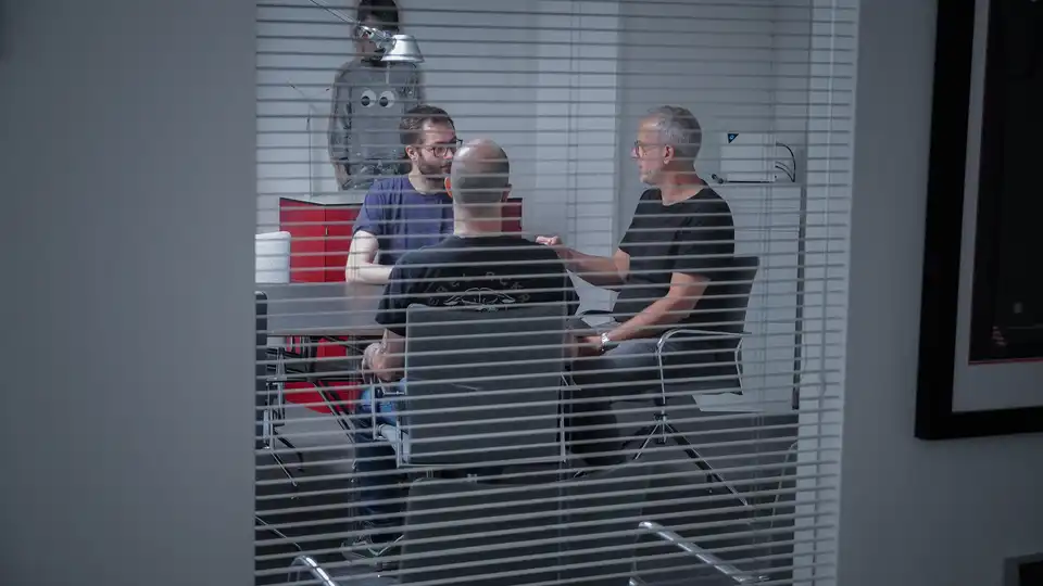 Mehrere Personen sitzen an einem Besprechungstisch