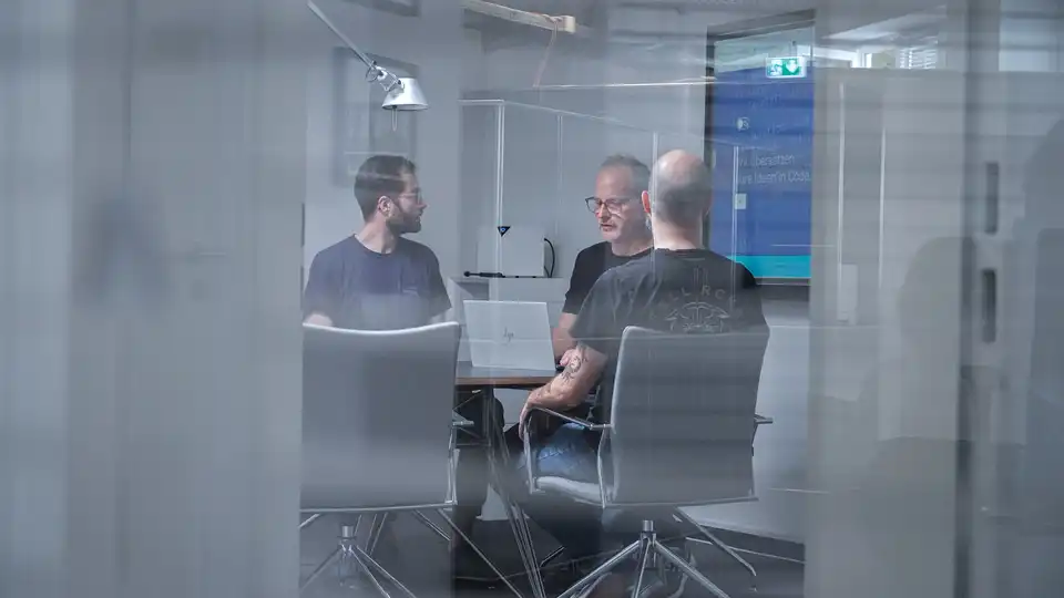 Mehrere Personen sitzen an einem Besprechungstisch