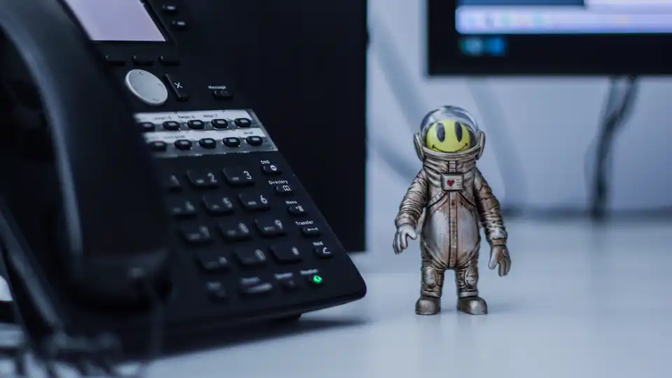 Ein Telefon, daneben eine lustige Figur im Raumanzug.