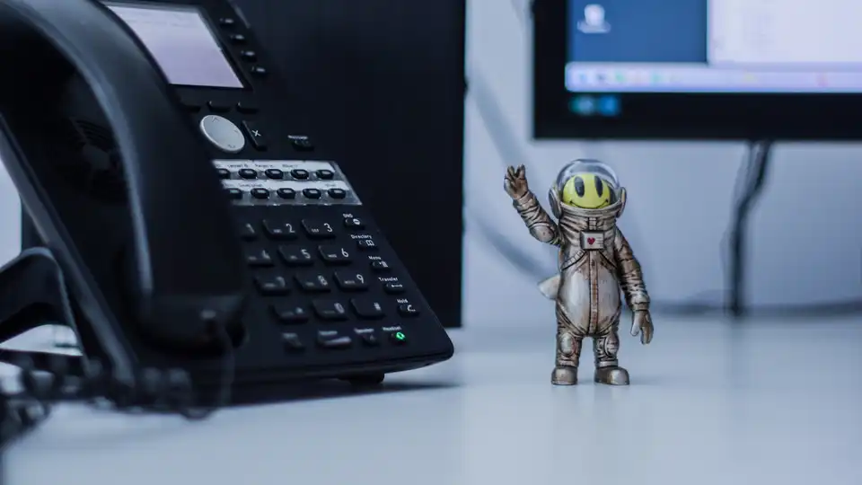 Ein Telefon, daneben eine lustige Figur im Raumanzug.