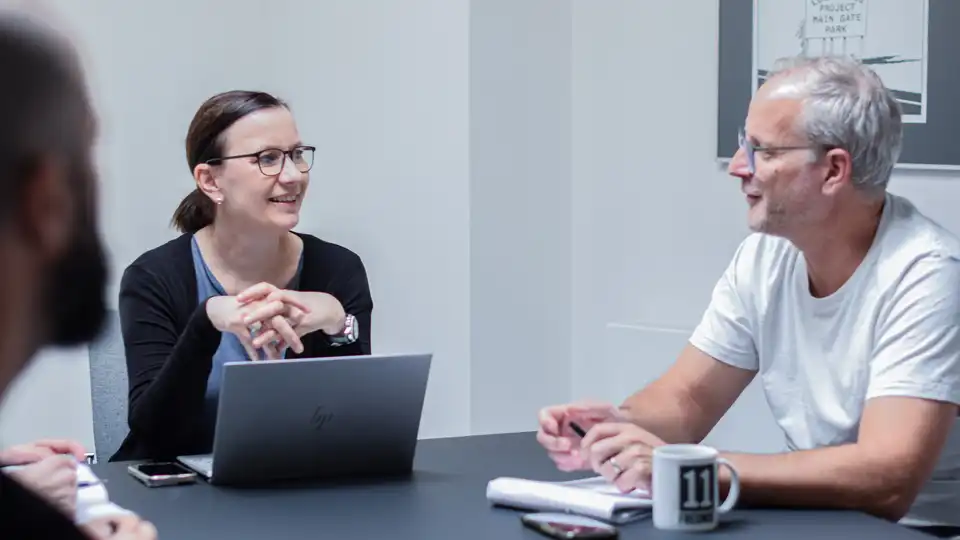 Zwei Personen im Gespräch an einem Tisch