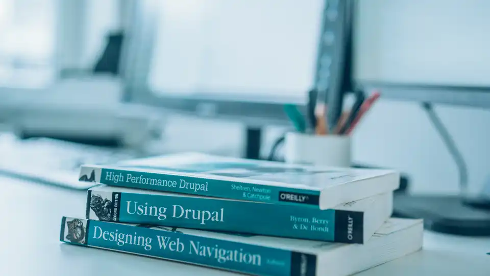 Ein Stapel Fachbücher liegt auf einem Schreibtisch