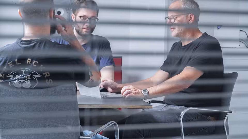 Mehrere Personen sitzen an einem Besprechungstisch