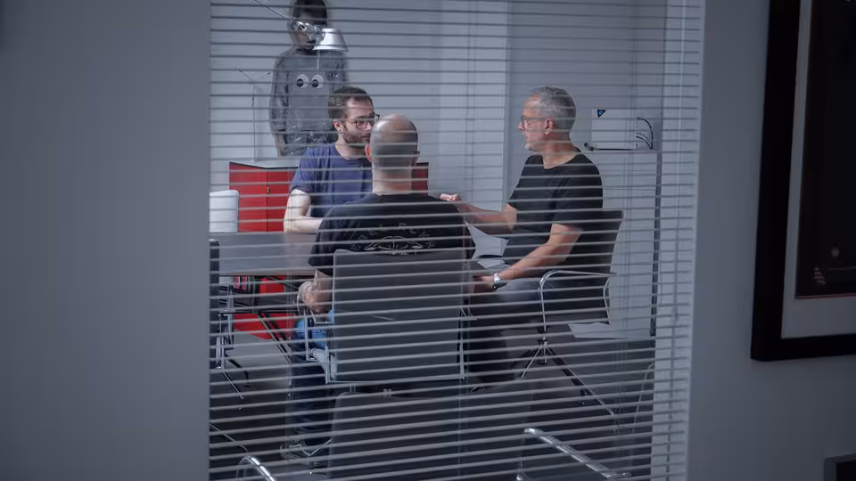 Mehrere Personen sitzen an einem Besprechungstisch