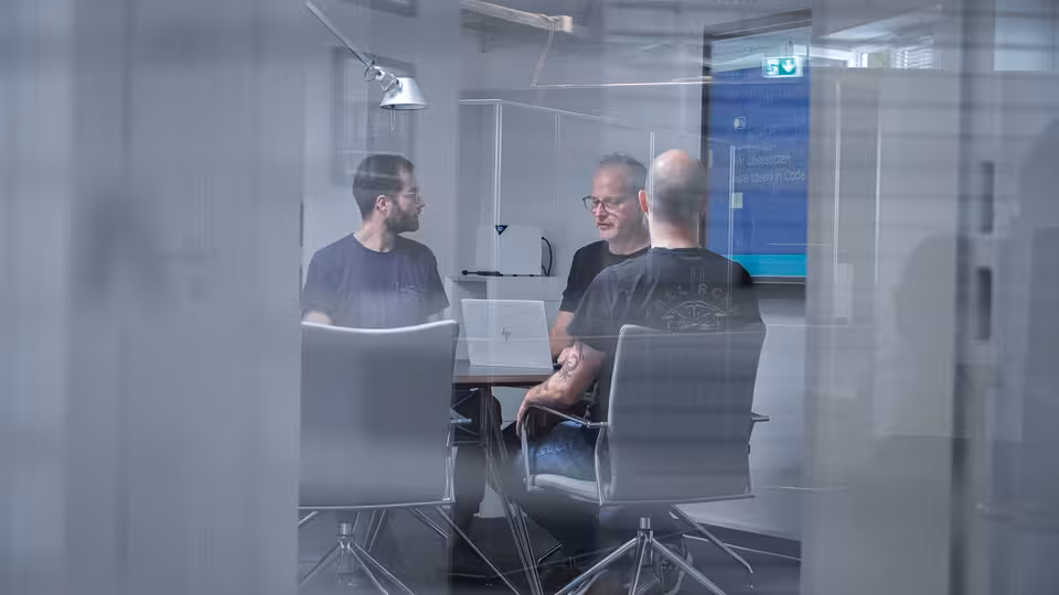 Mehrere Personen sitzen an einem Besprechungstisch