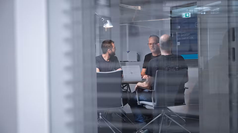 Mehrere Personen sitzen an einem Besprechungstisch