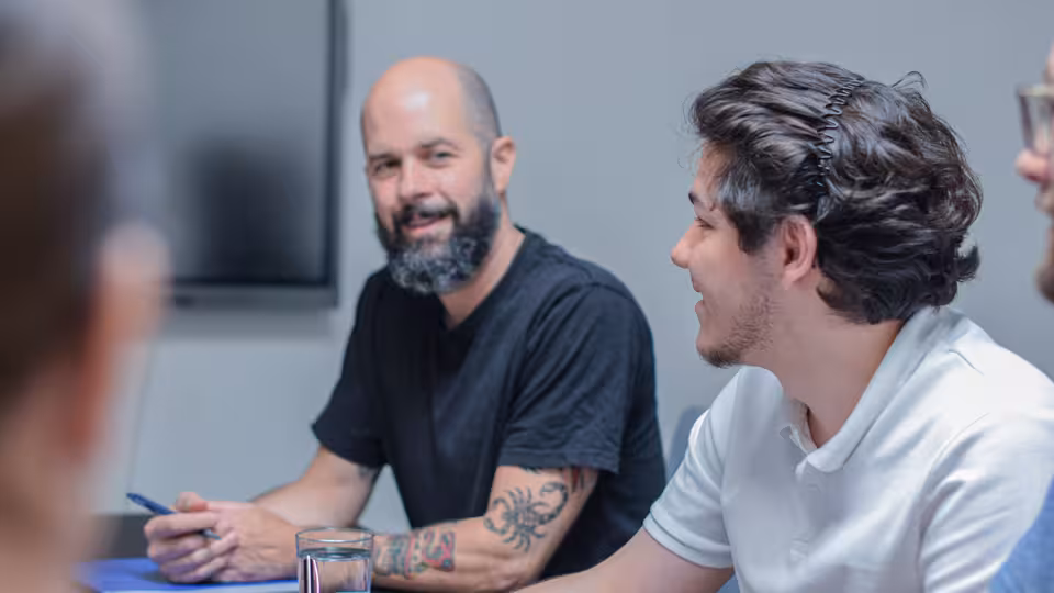 Mehrere Personen sitzen am Tisch