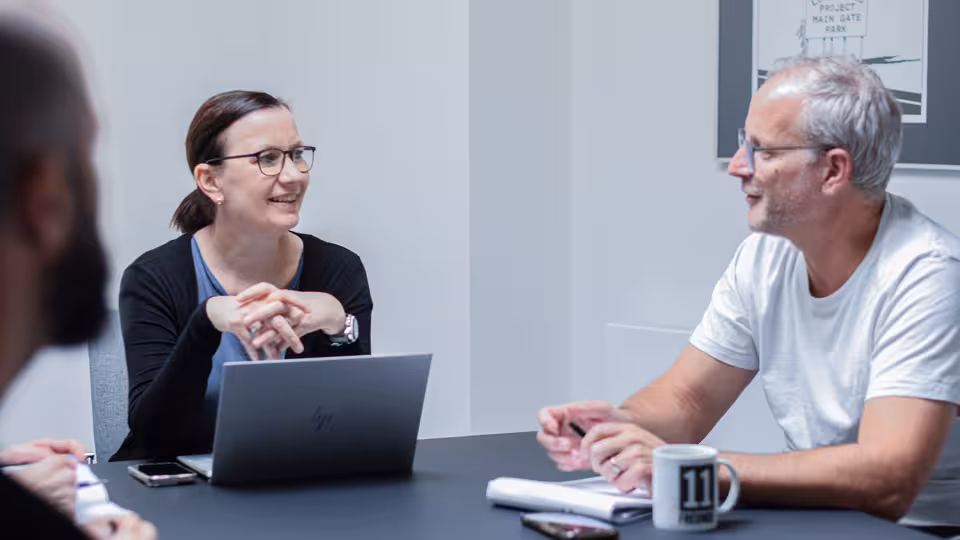 Zwei Personen im Gespräch an einem Tisch