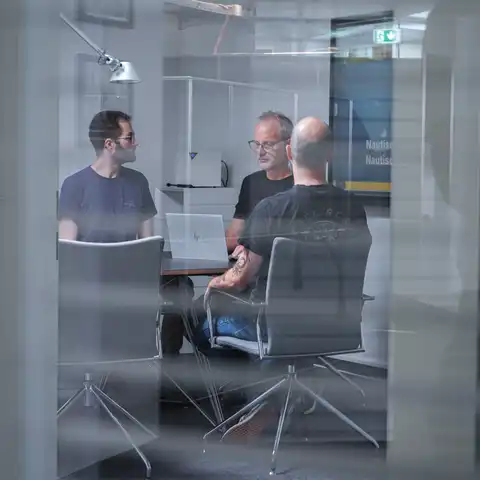 Mehrere Personen sitzen an einem Besprechungstisch