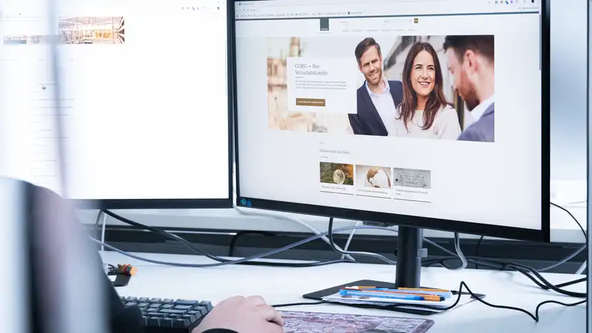 Eine Person sitzt vor einem Monitor, der die Website der Kanzlei GÖRG zeigt.