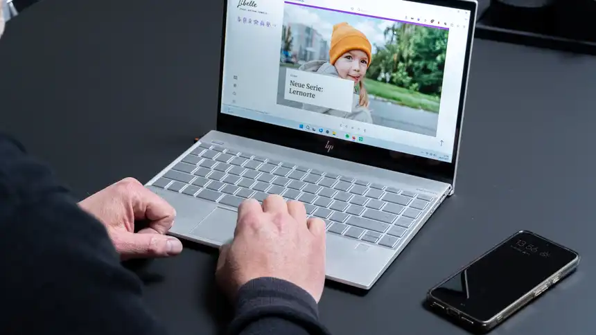 Eine Person sitzt vor einem Laptop, auf dem die Website des Libelle Magazins angezeigt wird