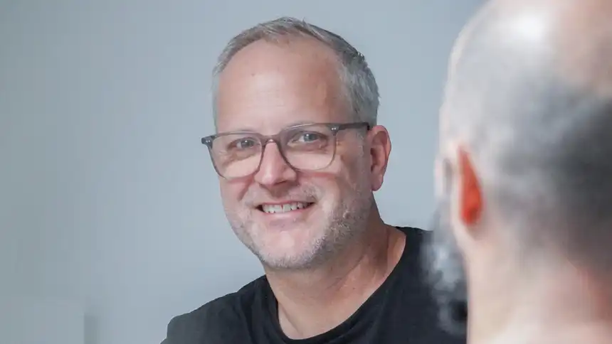 Zwei Personen sitzen an einem Besprechungstisch