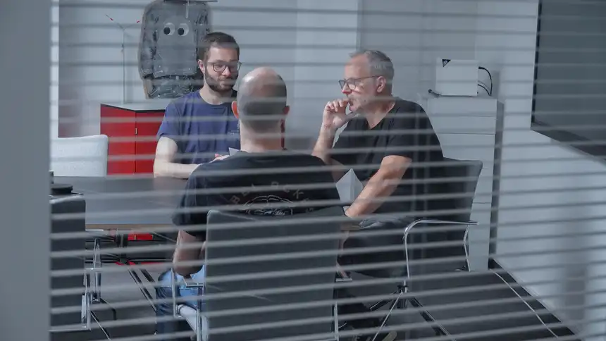 Mehrere Personen sitzen an einem Besprechungstisch