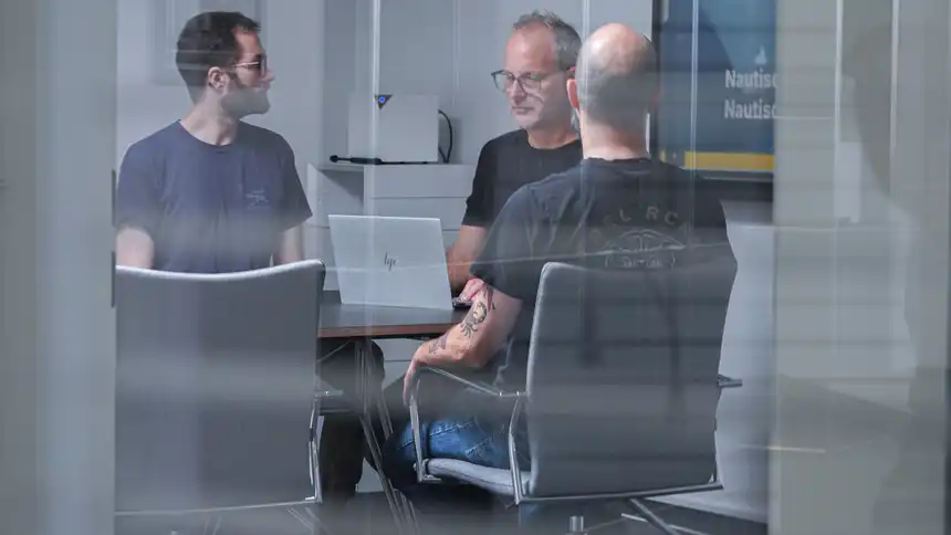 Mehrere Personen sitzen an einem Besprechungstisch