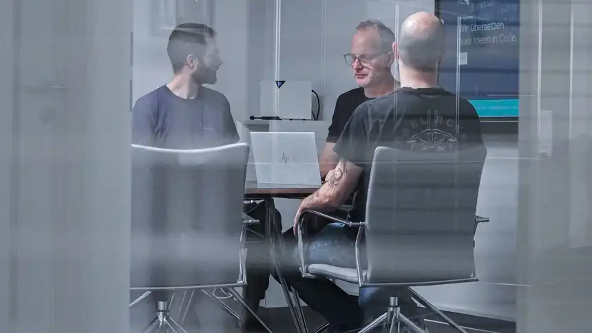 Mehrere Personen sitzen an einem Besprechungstisch