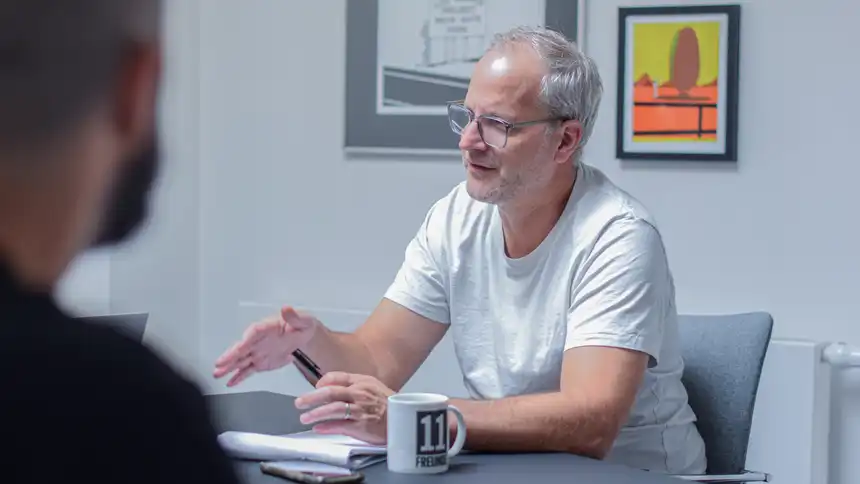 Zwei Personen sitzen am Tisch