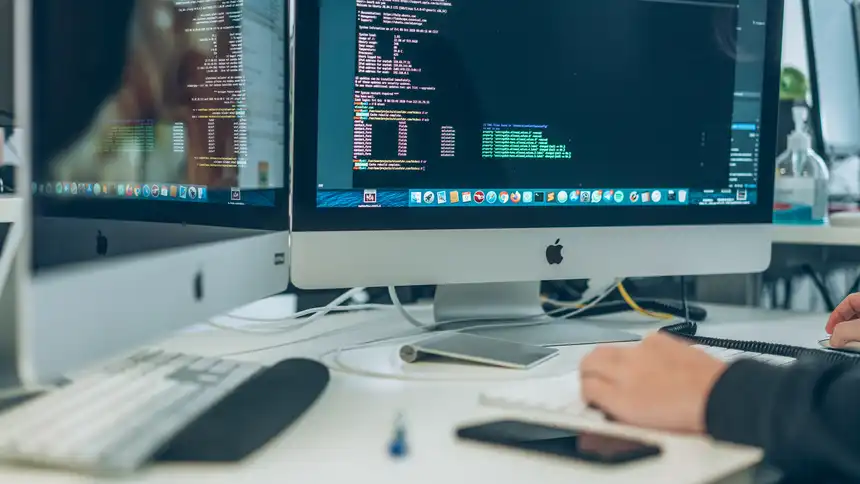 Schreibtisch mit zwei Apple Monitoren