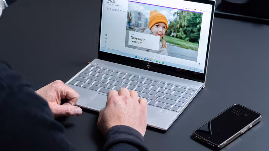 Eine Person sitzt vor einem Laptop, auf dem die Website des Libelle Magazins angezeigt wird
