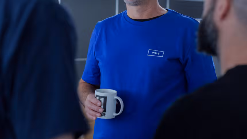 Zwei Personen stehen zusammen, eine hält eine Tasse in der Hand