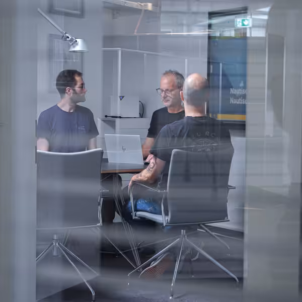 Mehrere Personen sitzen an einem Besprechungstisch